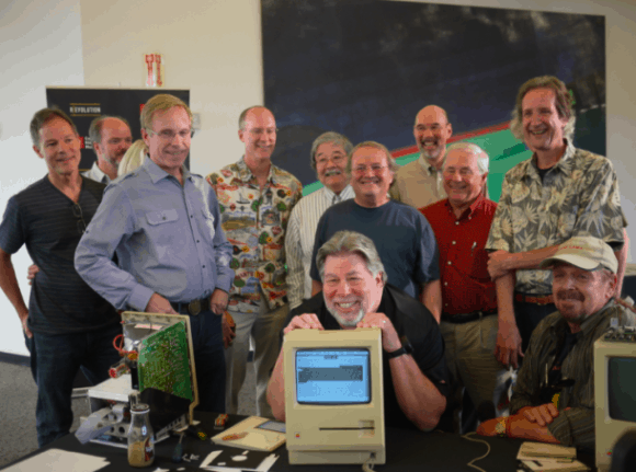 Apple Mitbegründer Steve Wozniak mit einem Twiggy Mac, umringt von Mitgliedern des Macintosh-Teams (v.l.n.r.): Larry Kenyon, Randy Wiggington, Ed Ruder, Terry Oyama, Andy Hertzfeld, Ron Nicholson, Jerry Manock und Dan Kottke. Foto: Dan Farber